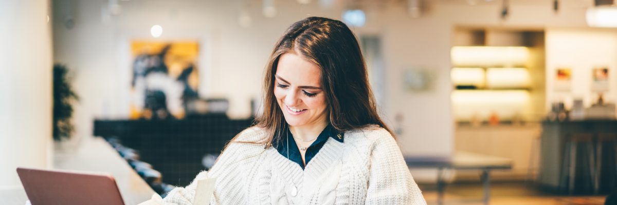 Businesswoman working on laptop in modern coworking.